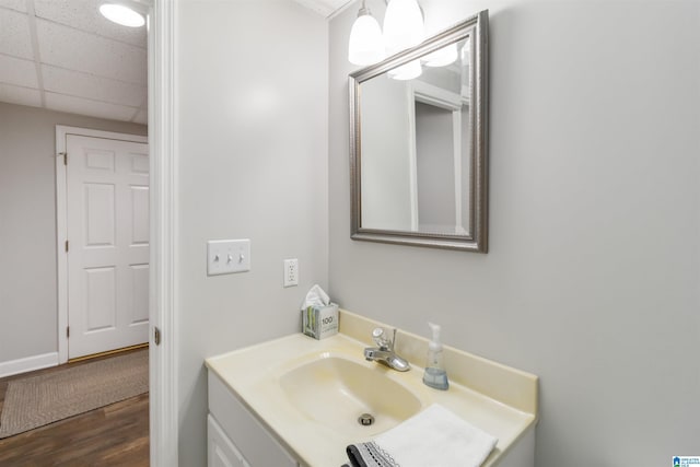 bathroom featuring vanity, hardwood / wood-style flooring, and a paneled ceiling