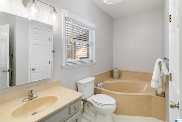 bathroom with vanity, a tub to relax in, and toilet