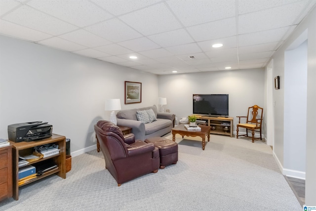 carpeted living room with a drop ceiling