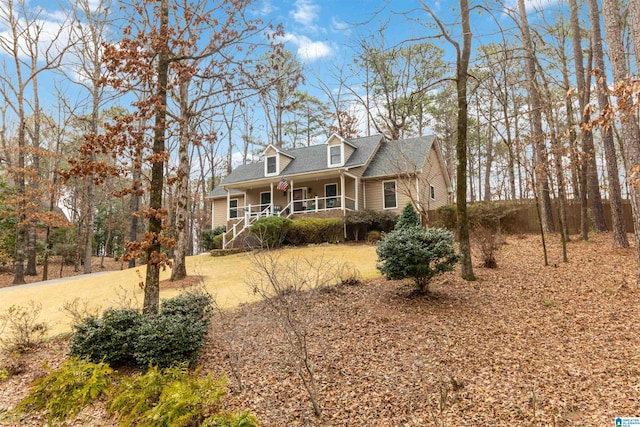 cape cod home featuring covered porch