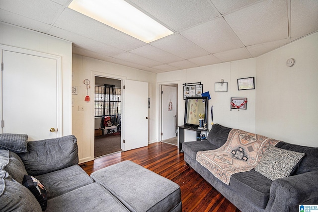 living room featuring a paneled ceiling and dark hardwood / wood-style flooring