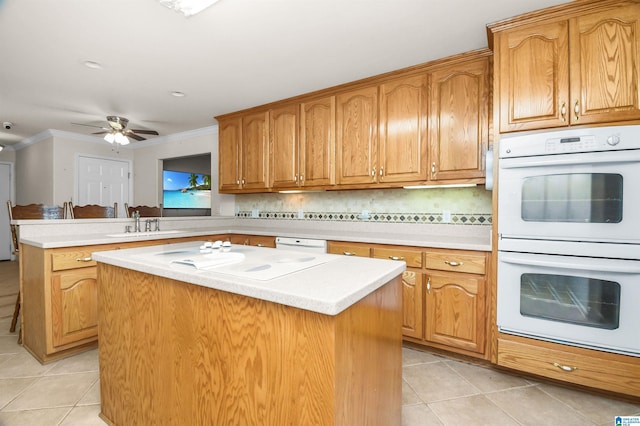 kitchen with light tile patterned flooring, white appliances, a center island, and kitchen peninsula