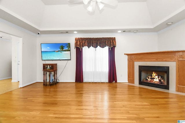 living room with ornamental molding, a tray ceiling, ceiling fan, hardwood / wood-style floors, and a high ceiling