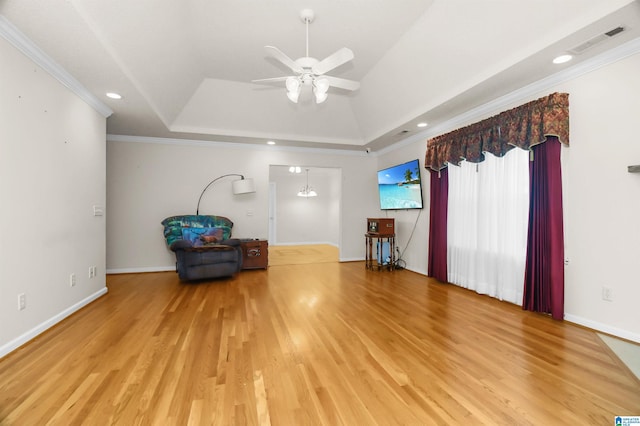 unfurnished room with a raised ceiling, wood-type flooring, ceiling fan, and crown molding