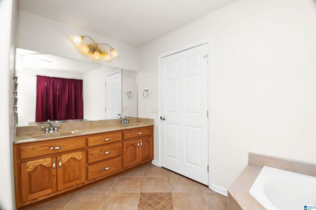 bathroom with a tub to relax in, vanity, and tile patterned flooring