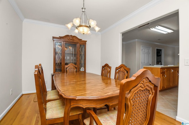 dining space featuring a notable chandelier, crown molding, and light hardwood / wood-style flooring