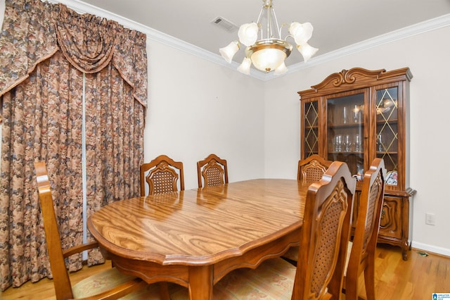 dining space with a notable chandelier, crown molding, and light hardwood / wood-style flooring