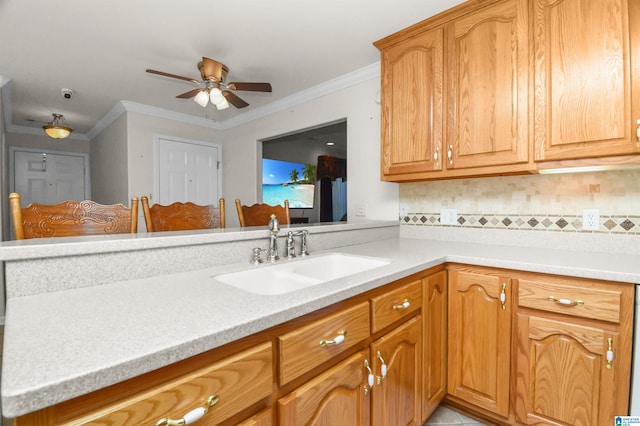 kitchen featuring tasteful backsplash, sink, ceiling fan, kitchen peninsula, and crown molding