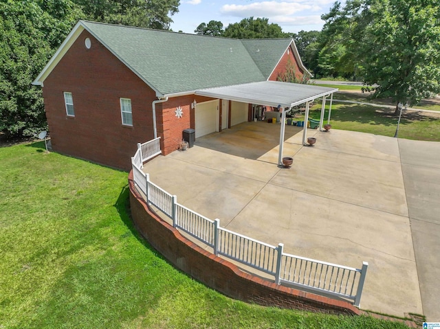 exterior space featuring a garage, a yard, and a carport