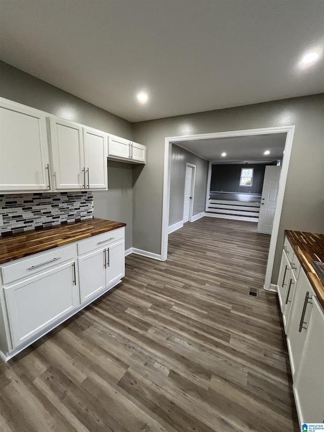 kitchen with white cabinetry, dark wood-type flooring, and wood counters