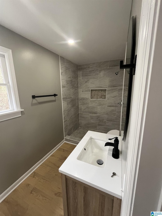 bathroom featuring sink, hardwood / wood-style floors, and tiled shower