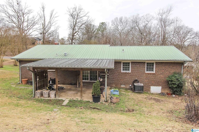 back of house featuring central AC, a patio, and a lawn