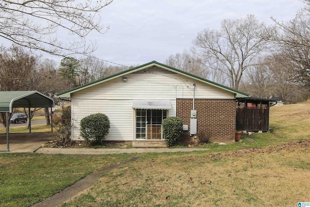 view of home's exterior with a carport and a yard