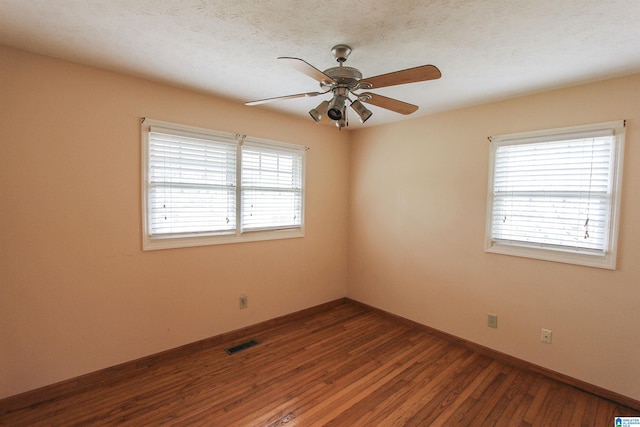 unfurnished room featuring ceiling fan, dark hardwood / wood-style flooring, and a textured ceiling