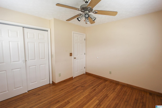 unfurnished bedroom featuring hardwood / wood-style flooring, ceiling fan, and a closet