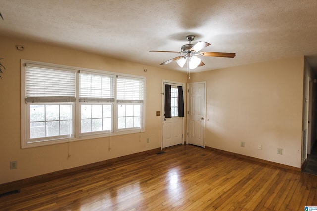 unfurnished room featuring dark wood-type flooring, ceiling fan, and a textured ceiling