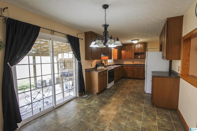 kitchen with sink, white appliances, decorative light fixtures, and a chandelier