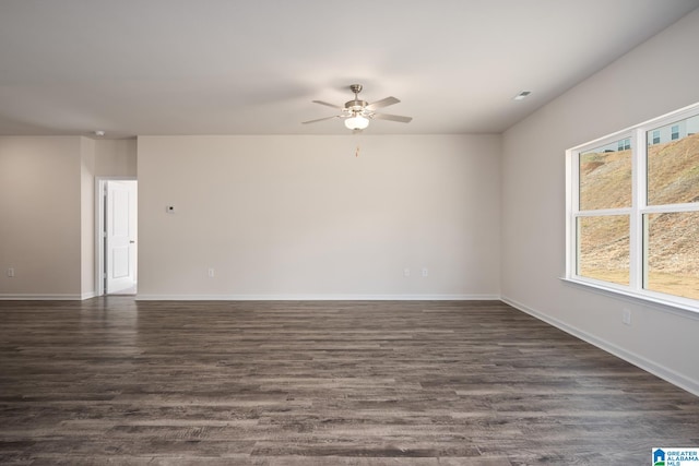 empty room with plenty of natural light, dark hardwood / wood-style floors, and ceiling fan