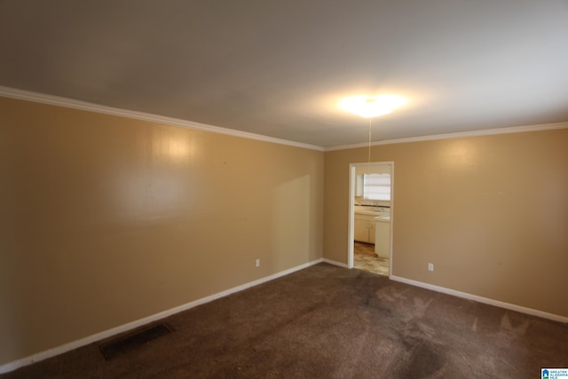 empty room with crown molding and carpet