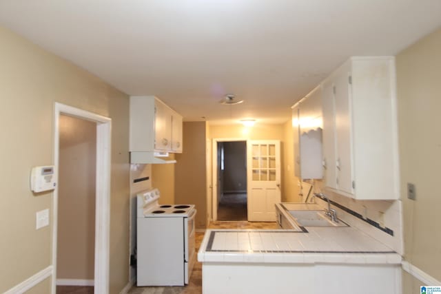 kitchen with white cabinetry, white range with electric cooktop, tile counters, and sink