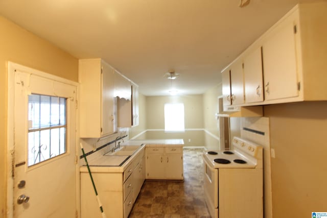 kitchen with electric stove, sink, and white cabinets