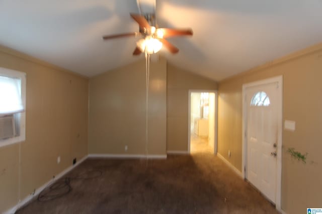 foyer entrance with vaulted ceiling, ceiling fan, and dark colored carpet