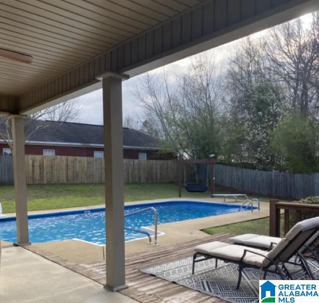 view of pool featuring a yard, a diving board, and a patio area