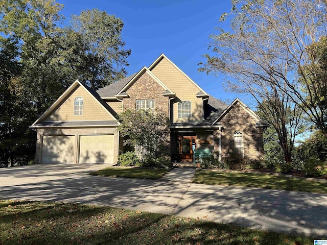 view of front of home with a garage, concrete driveway, and a front lawn