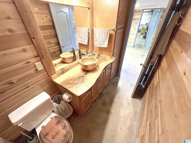 540 County Road 175, Crane Hill, AL 35053 - bathroom featuring wooden walls, concrete flooring, toilet, and vanity