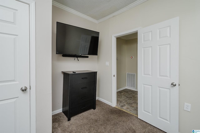 carpeted bedroom with ornamental molding and a textured ceiling