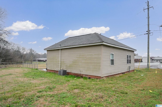 view of side of property featuring central AC unit and a lawn