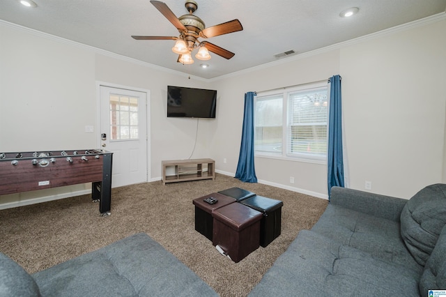 living room with crown molding, ceiling fan, and carpet