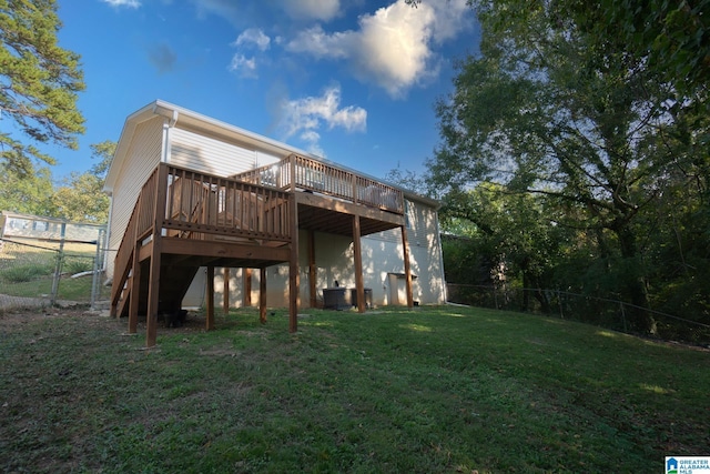 back of house featuring a wooden deck and a yard