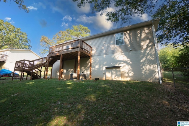 back of house with a wooden deck and a yard