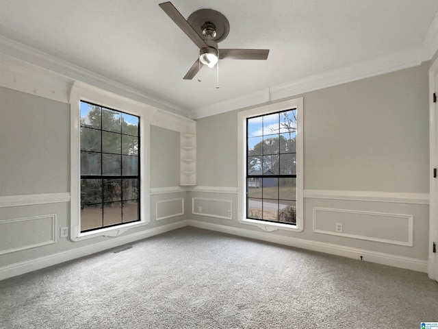 carpeted spare room with ceiling fan and ornamental molding