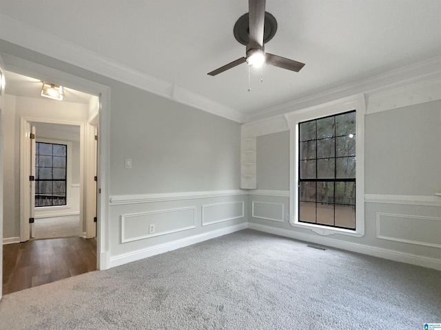 empty room featuring crown molding, carpet flooring, and ceiling fan