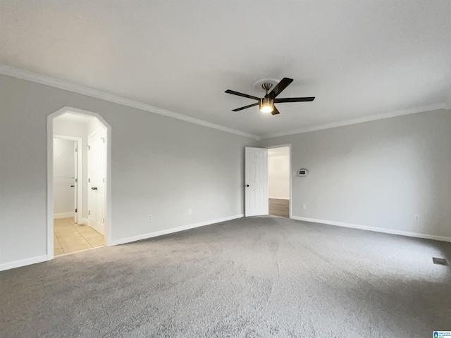 spare room with crown molding, light carpet, and ceiling fan