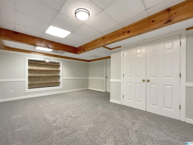 basement featuring a paneled ceiling and carpet flooring