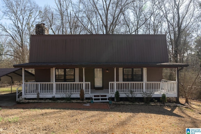 farmhouse-style home with covered porch, a carport, and a front yard