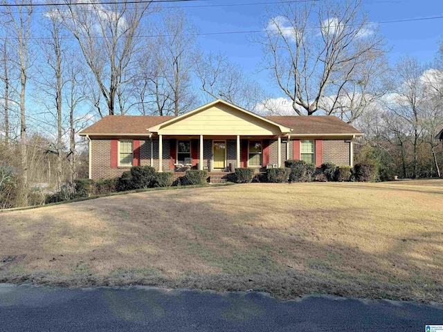 ranch-style house featuring covered porch and a front yard