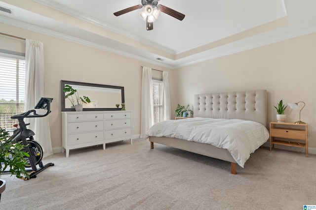 bedroom with crown molding, light colored carpet, a raised ceiling, and ceiling fan