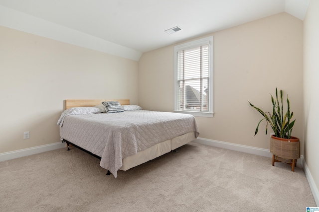 bedroom with lofted ceiling and light carpet