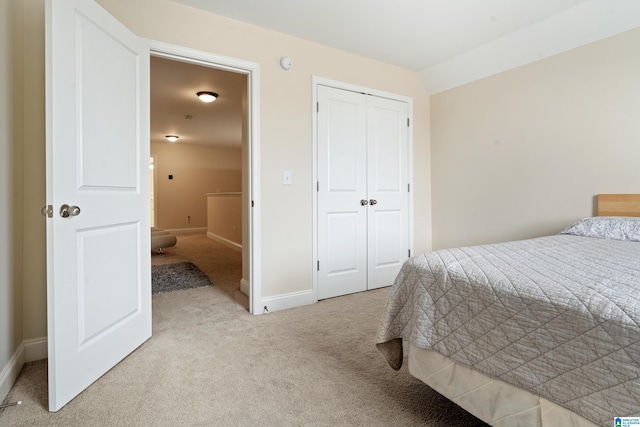 bedroom featuring light colored carpet and a closet