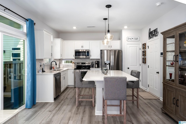 121 Palmer Cv, Birmingham, AL 35242 - kitchen featuring stainless steel appliances, light wood finished floors, a breakfast bar area, and recessed lighting