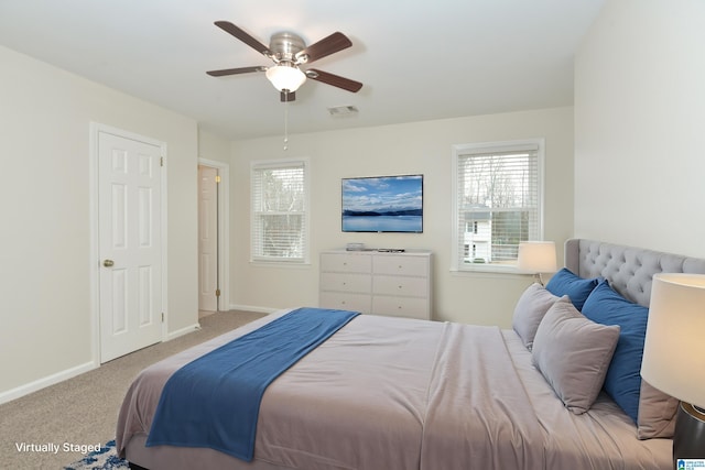 bedroom with multiple windows, light carpet, and ceiling fan