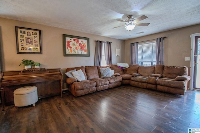 living room with ceiling fan, dark hardwood / wood-style floors, and a textured ceiling