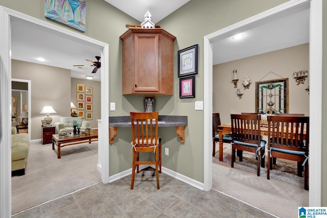 kitchen with light colored carpet and ceiling fan