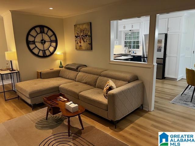 living room with light hardwood / wood-style flooring and ornamental molding