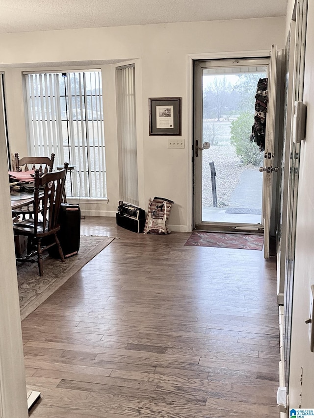 entrance foyer with hardwood / wood-style floors and a textured ceiling