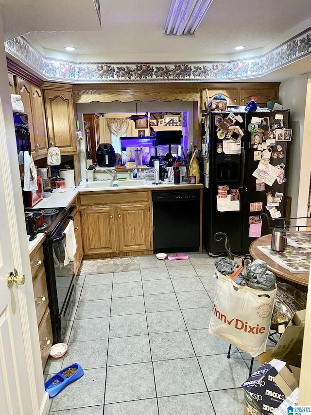 kitchen featuring sink, light tile patterned floors, and black appliances